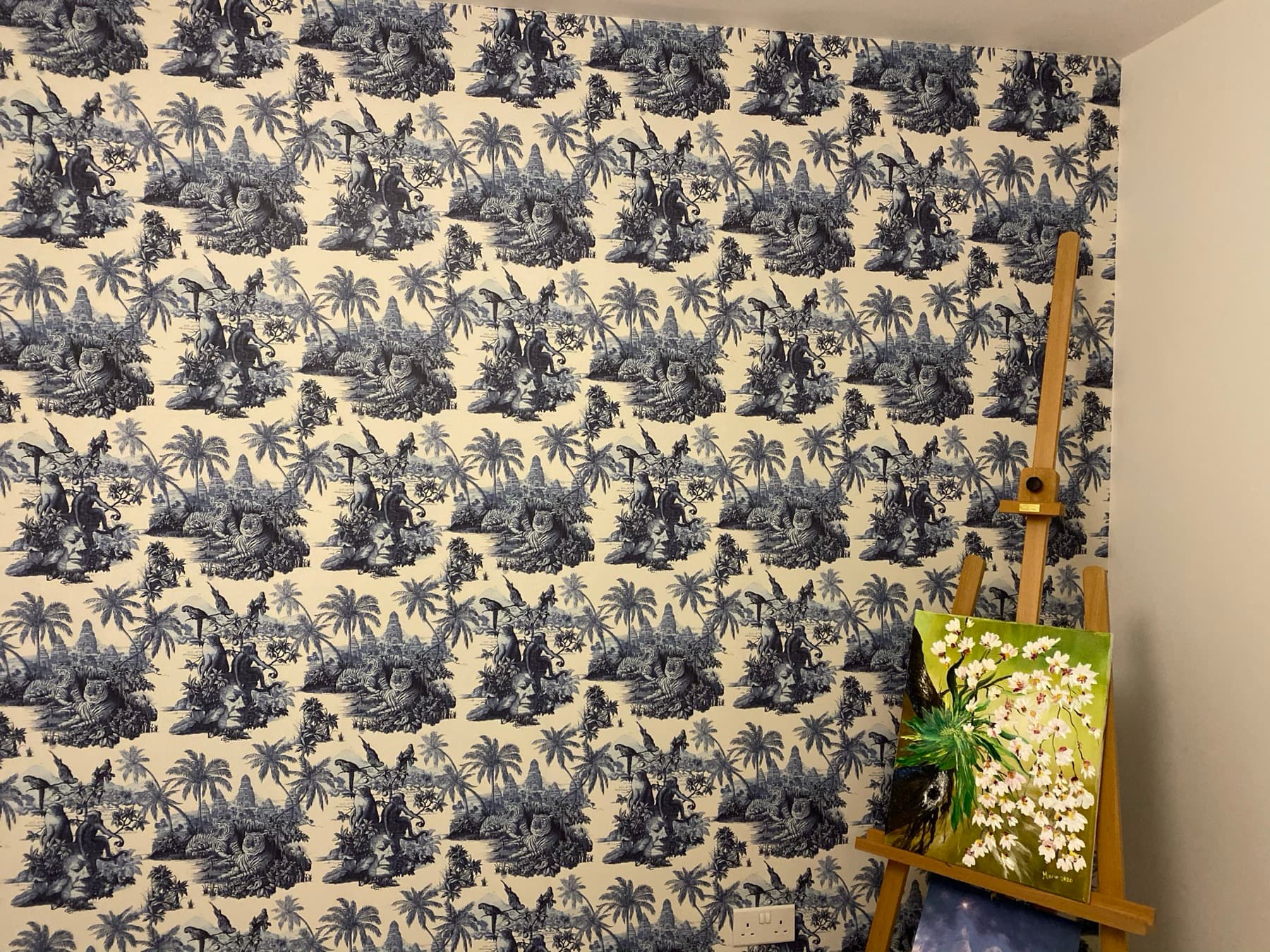 Bedroom wall in a blue and cream toile jungle print, pattern matched corner to corner